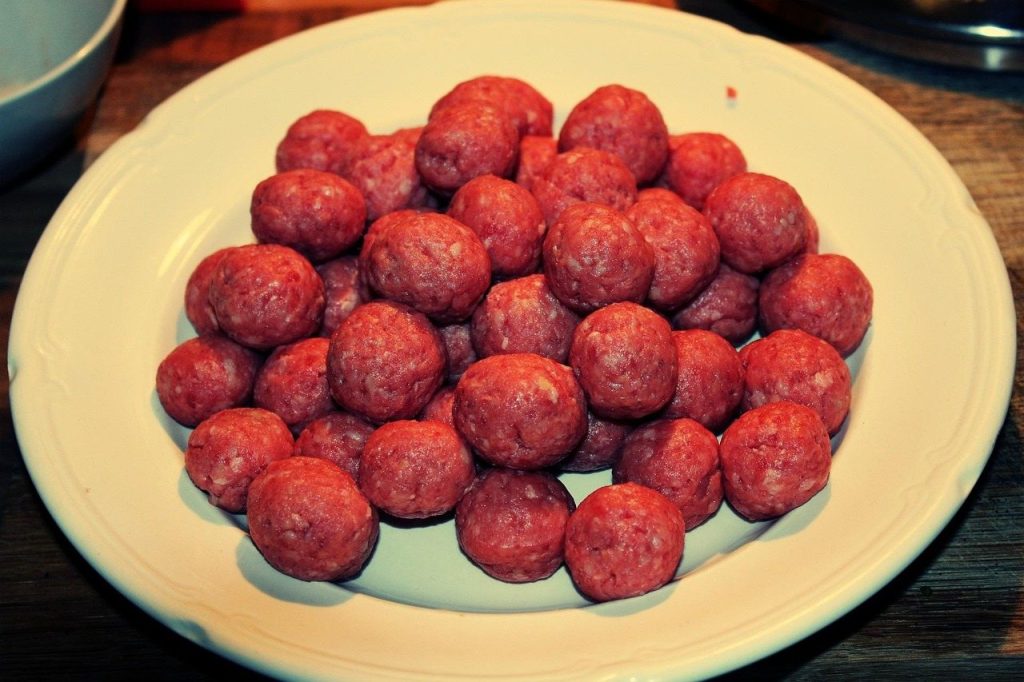 Raw ground meat balls for dogs, illustrating the question of should dogs eat raw meat