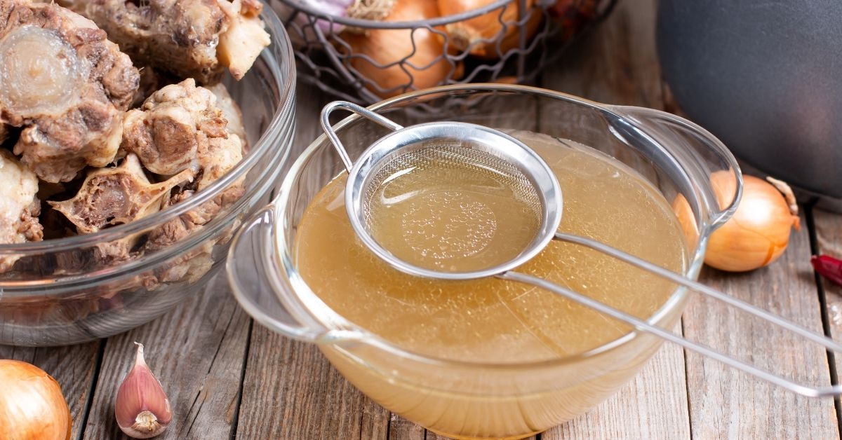 A photograph of the straining process for bone broth, illustrating why dogs that eat dry food are often dehydrated and need natural electrolytes