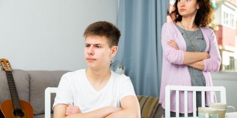 A mother and her angry son in an emotional conflict illustrating the parent child order