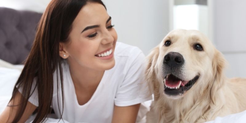 Happy dog with a happy owner illustrating that a dog is not a toy and how to properly care for a dog through emotional balance
