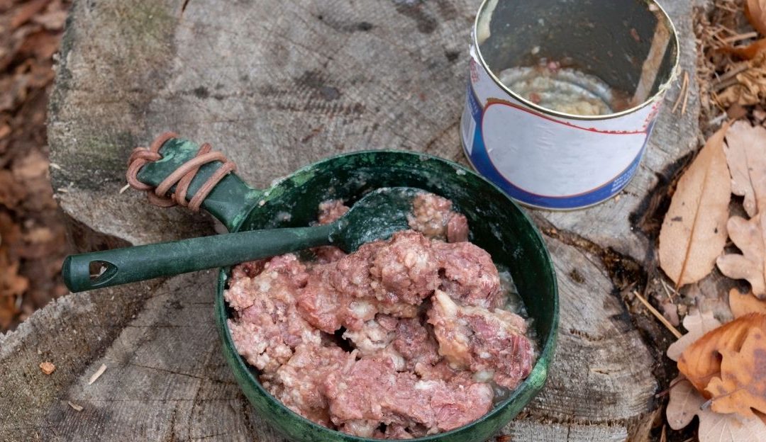 An open commercial metal can of industrial pet food showing how canned dog food harms dogs