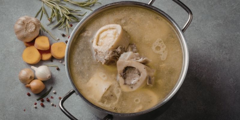 Bone broth and broccoli as natural prebiotics that prepare the dog's microbiome for dietary change.