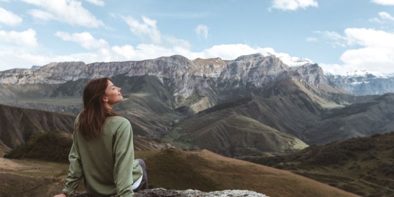 Woman enjoying fresh air in mountain nature supporting fight against hiv health awareness concept